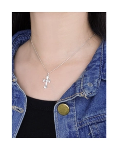 Close-up of S925 sterling silver cross necklace pendant on model with denim jacket