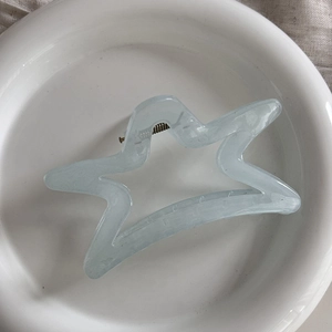 Detailed close-up of a blue star-shaped hair claw clip made of translucent acrylic