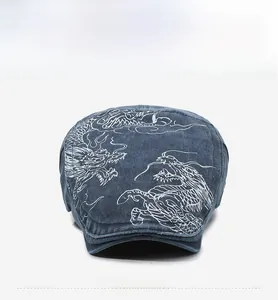 Detailed front view of washed denim flat cap featuring intricate dragon embroidery