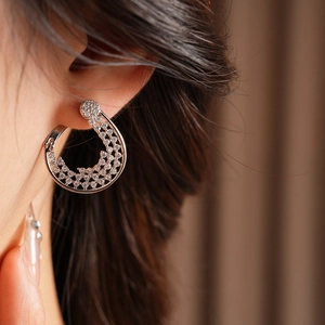 Close-up of gold-plated hoop earrings with cubic zirconia on a model's ear