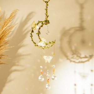 Detail of moon suncatcher with gold butterflies, green vines, and crystal prisms