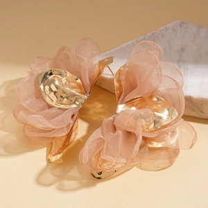 Détail des boucles d'oreilles fleurs en mousseline rose avec accents dorés élégants