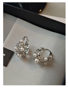 Detail of silver basket earrings featuring delicate pearls and sparkling rhinestones