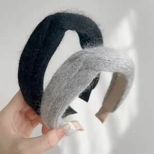 Detailed view of plush knitted cross-knot headbands in black and grey mohair textures