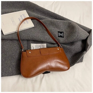 Close-up of brown PU leather crescent shoulder bag with metallic silver rivet detailing