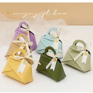 Detail of luxury macaron-colored handbag-style gift boxes with elegant ribbon and charms