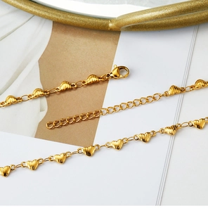 Macro view of gold-plated heart chain necklace with lobster clasp and extension chain