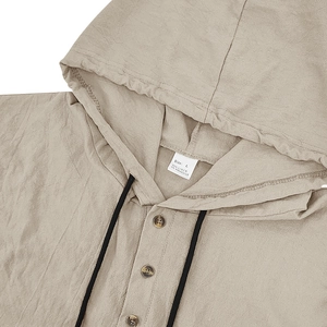 Close-up of beige linen hooded shirt neckline with natural fabric texture and buttons