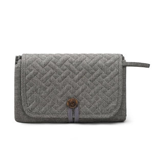 Portable waterproof quilted baby changing mat in grey with wood button closure and handle