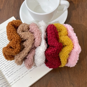 Teddy fabric scrunchies in seven assorted autumn colors on a wooden table setup