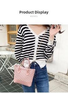 Detail of pink plaid pattern handbag with golden chain strap in outdoor cafe setting