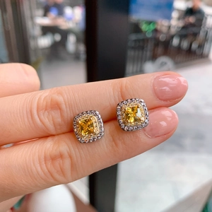 Macro shot of square yellow diamond stud earrings with micro pavé white stones
