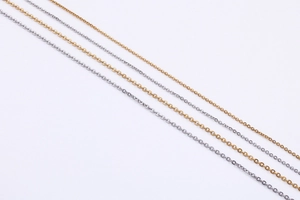 Detailed close-up of gold and silver minimalist O-word cable chains for necklaces