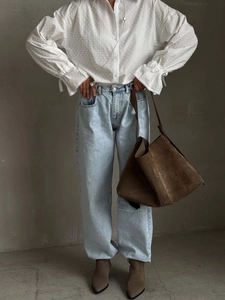 Chic white polka dot textured blouse with bell sleeves paired with light blue jeans