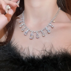 Close-up of silver teardrop crystal necklace being worn by a model for elegant styling