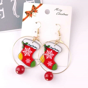 Christmas stocking earrings with snowflake pattern and red bead on a white display card