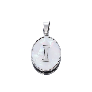 Macro shot of oval stainless steel pendant with letter I on white mother of pearl