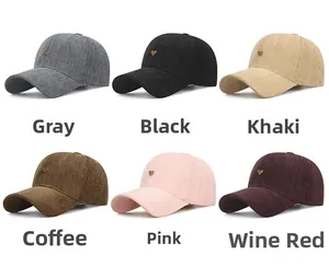 Detail view of multi-color baseball caps with golden metal heart logo and herringbone fabric
