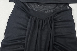 Detail aus schwarzem Netzstoff mit eleganten Raffungen und drapierter Textur