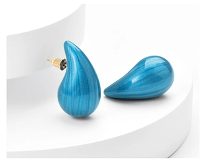 Detailed macro view of vibrant blue teardrop earrings with a polished metallic finish