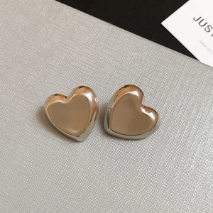 Close-up of two-tone heart stud earrings with silver borders and rose gold centers