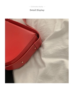 Close-up of precise stitching and metallic rivet details on a bright red faux leather bag