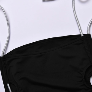 Close-up of black one-piece swimsuit featuring sparkling silver thin straps on elastic fabric