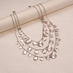 Macro shot of silver layered fringe necklace with hammered metal circular pendants