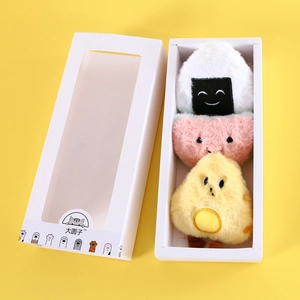 Detailed view of plush cat toys in rice ball shapes within a white gift display box