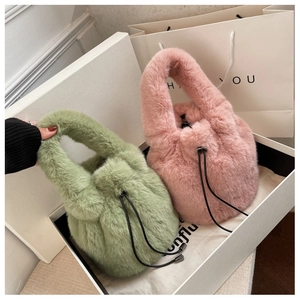 Detail view of plush bucket bags in sage green and pink with drawstring closure