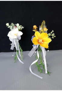 Detailed view of white cymbidium orchid champagne glass decor with ribbons and beads