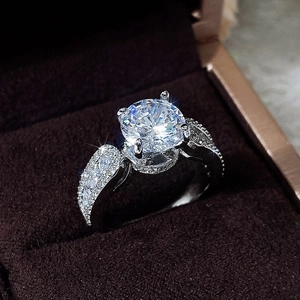 Macro detail of a classic four-prong round zircon engagement ring in a velvet box
