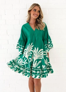 Detail von V-Ausschnitt und Rüschen-Glockenärmeln am grünen Tropenmuster-Kleid