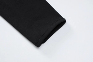 Détail du gros plan sur la couture double aiguille et le tissu en maille noire sur la manche