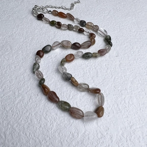 Detailed view of bohemian necklace with natural irregular stone beads and steel chain