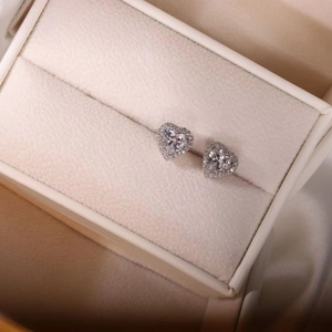 Elegant silver heart stud earrings with cubic zirconia stones in a jewelry box