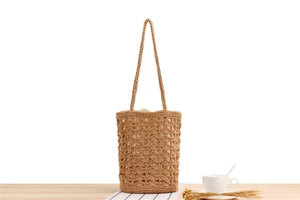 Close-up of a khaki hollow woven cotton rope tote bag in a minimalist summer setting