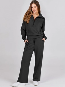 Detail view of women's black loungewear set with quarter-zip top and wide-leg sweatpants