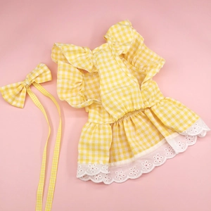 Close-up of a yellow plaid dog dress with lace trim and matching ribbon headpiece