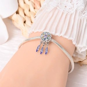 Close-up of dreamcatcher charm bracelet with multicolored zircons and feather pendants