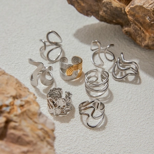 Abstract geometric titanium steel rings with lava texture and wave designs in a still life