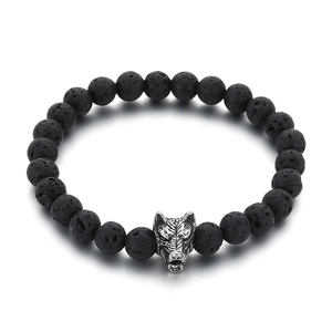 Lava stone bead bracelet with silver wolf head charm on a white background