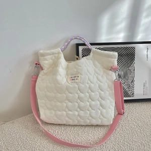 Detail van witte gewatteerde hartjes canvas tas met gekleurde handvatten en roze riem