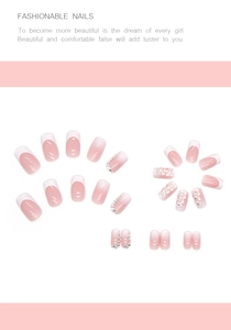 Detail of pink gradient press-on nails with delicate white flower and rhinestone accents