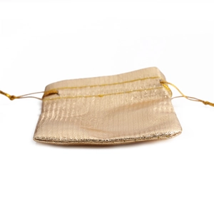 Golden woven drawstring pouch for jewelry and gift packaging with texture detail