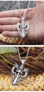 Detailed close-up of a silver dragon pendant coiled around a sword on a chain link