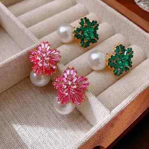 Floral pearl earrings with pink and green crystals on a velvet jewelry display tray
