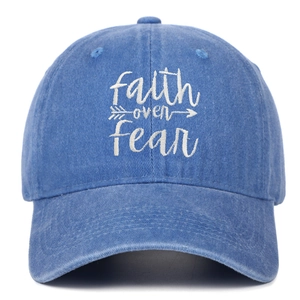 Detailed white embroidery of faith over fear text on washed blue cotton baseball cap