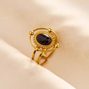 Macro shot of vintage gold ring featuring a black marble stone and hollow double band