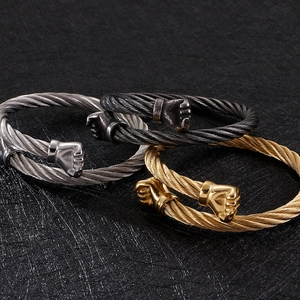 Detailed view of three-color steel cable bracelets with textured fist head charms